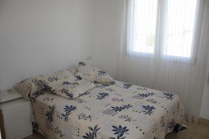 1 dormitorio con 1 cama con edredón azul y blanco en Lidia LOCDENIA, en Els Poblets