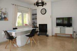 sala de estar con mesa y reloj en la pared en Lidia LOCDENIA, en Els Poblets