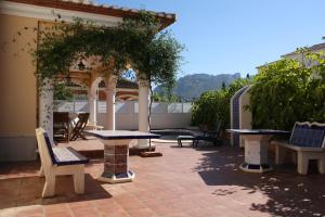 un patio al aire libre con mesas y sillas y un cenador en Lidia LOCDENIA, en Els Poblets