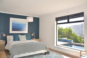 Un dormitorio con una cama y una ventana grande. en Luxury Modern House Western Cape Fish Hoek, en Ciudad del Cabo