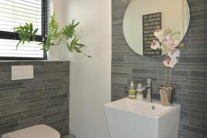 Un baño con un lavabo blanco y un espejo. en Luxury Modern House Western Cape Fish Hoek, en Ciudad del Cabo 44 fotos más