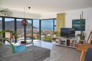 Una sala de estar con un sofá y un televisor. en Luxury Modern House Western Cape Fish Hoek, en Ciudad del Cabo