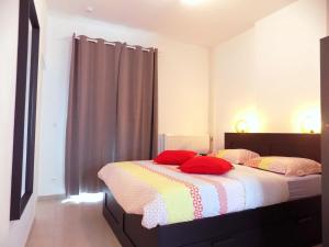 1 dormitorio con 2 camas con almohadas rojas. en La Lodelinsartoise - Meublé de vacances 3 clés, en Charleroi