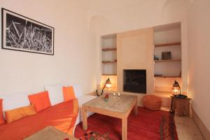 a living room with a couch and a fireplace at Riad Dar Aicha en Exclusivité in Marrakesh