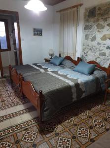 a bedroom with a large bed with blue pillows at Two Flowers Hotel in Pedoulas