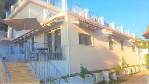 una grande casa bianca con scale e ombrellone di Appartamenti Borgo Panoramico n.1 a Tropea