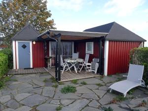 a red shed with a table and chairs on a patio at 1C, Första parkett, 50m till badstrand in Byxelkrok