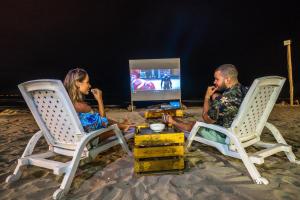 a man and a woman sitting in chairs on the beach at Howard Johnson by Wyndham Montañita in Montañita