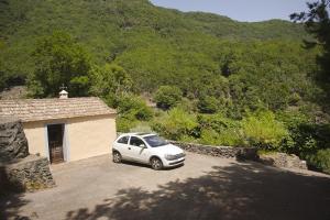 a white car parked in front of a building at Casa Rural Los Patos in Hermigua