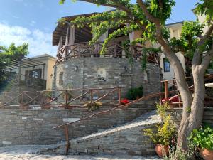 a house with a stone wall and stairs at Iliovolo Guesthouse in Mileai