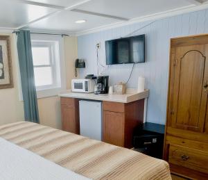 a room with two beds and a kitchen with a microwave at Georgianne Inn & Suites check in 212 Bulter Ave in Tybee Island