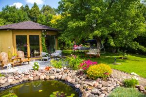 un jardín con estanque, mesa y sillas en Guests house "Like Home", en Sigulda