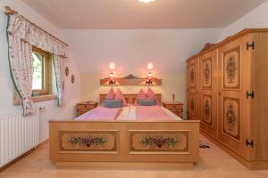 una camera da letto con un grande letto con cuscini rosa e blu di Tom's Jägerlodge a Jenig
