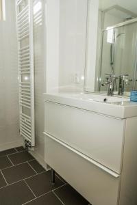 een witte badkamer met een wastafel en een spiegel bij Chaletparc Krabbenkreek Zeeland - Chalet 94 in Sint Annaland
