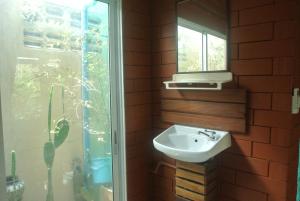 łazienka z umywalką i oknem w obiekcie P.Y. Guest House w mieście Kanchanaburi