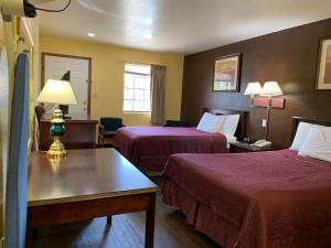 a hotel room with two beds and a table with a lamp at Southern Nights Motel in Waldron
