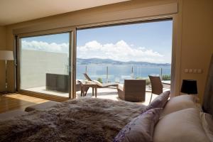 a living room with a large window with a view of the ocean at Villa mirador de Sanxenxo in Sanxenxo