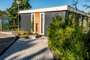 a small house with a garden in front of it at Chaletparc Krabbenkreek Zeeland - Chalet 94 in Sint Annaland