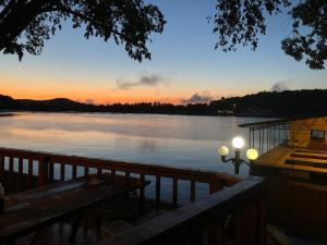 a sunset over a lake with a bench and a street light at Point View Resort in Camdenton