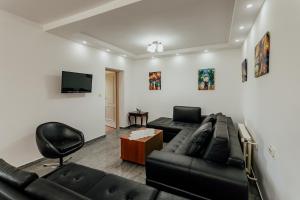 a living room with a black couch and a tv at Apartmani Jasna in Herceg-Novi