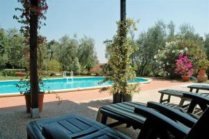 a swimming pool with picnic tables and trees and a swimming pool at La Piaggia in Altopascio