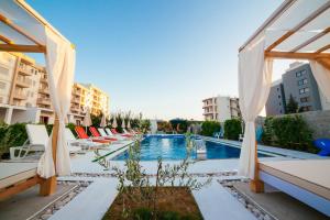 a hotel with a pool and chairs and buildings at Apartments Paradise in Ulcinj