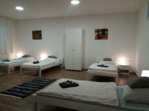 a room with three beds in it with lights at Apartman Romy in Pančevo