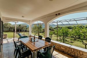 an outdoor patio with a wooden table and chairs at Apartmani Jasna in Herceg-Novi