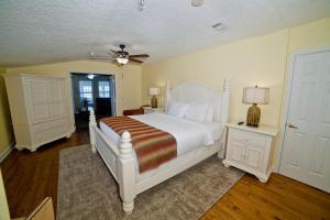a bedroom with a white bed and a ceiling fan at DeSoto Beach Terraces in Tybee Island
