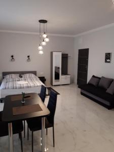 sypialnia z łóżkiem, stołem i kanapą w obiekcie Apartamenty Polna w Ostrowcu Świętokrzyskim