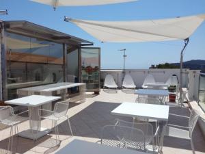 a patio with white tables and chairs on a roof at La Casa di Gino in San Nicola