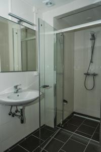 a bathroom with a sink and a glass shower at Chaletparc Krabbenkreek Zeeland - Chalet 94 in Sint Annaland +21 photos