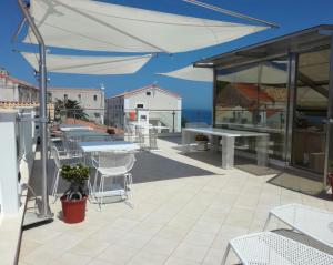 a patio with tables and chairs and a view of the ocean at La Casa di Gino in San Nicola