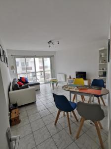 sala de estar con mesa y sillas en appartement vue sur mer, en Saint-Jean-de-Monts