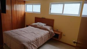 1 dormitorio pequeño con 1 cama y 2 ventanas en San Marino, en Xochimilco