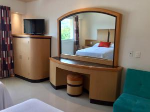 a hotel room with a bed and a mirror at Hotel Nilo in Acapulco