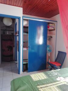 een kamer met een blauwe deur in een slaapkamer bij Chambre d'hôte la Calebasse in Sainte-Anne