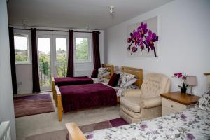 a bedroom with a bed and a couch and a chair at Bay Tree House Bed & Breakfast in Barnet