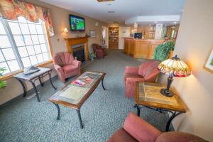 sala de estar con sillas rosas y mesa en Woodland Inn, en Meadow Lake