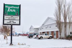 a sign for a woodland inn in the snow at Woodland Inn in Meadow Lake