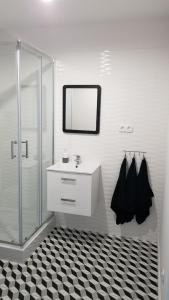 y baño con ducha, lavabo y espejo. en Apartament Turkusowy Ruciane-Nida en Ruciane-Nida