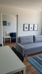 un soggiorno con divano blu e tavolo di Apartament Turkusowy Ruciane-Nida a Ruciane-Nida