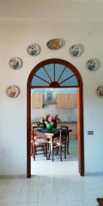 une salle à manger avec une table et des assiettes murales dans l'établissement Villalba, à Castellammare del Golfo