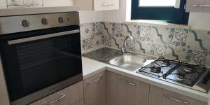 a kitchen with a stove and a sink at Appartamento Scarlatti in Trapani