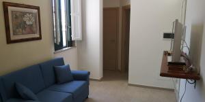 a living room with a blue couch and a tv at Appartamento Scarlatti in Trapani