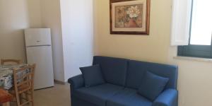 a living room with a blue couch and a refrigerator at Appartamento Scarlatti in Trapani