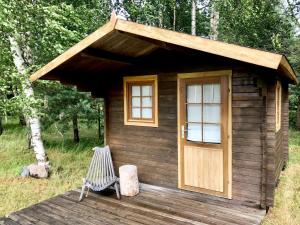 une cabine en bois avec un banc et une porte dans l'établissement Suurkivi Nature Escape, à Häädemeeste