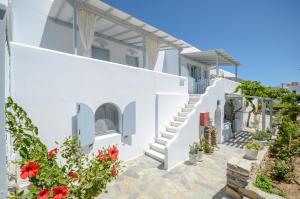 una casa blanca con escaleras y flores en Maroussa Studios en Agia Anna Naxos