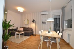 a living room with a table and a couch at Kraljev Park sa parking mestom in Novi Sad