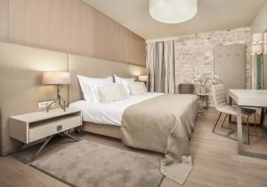 a hotel room with a bed, desk, chair and lamp at Art Hotel Kalelarga in Zadar